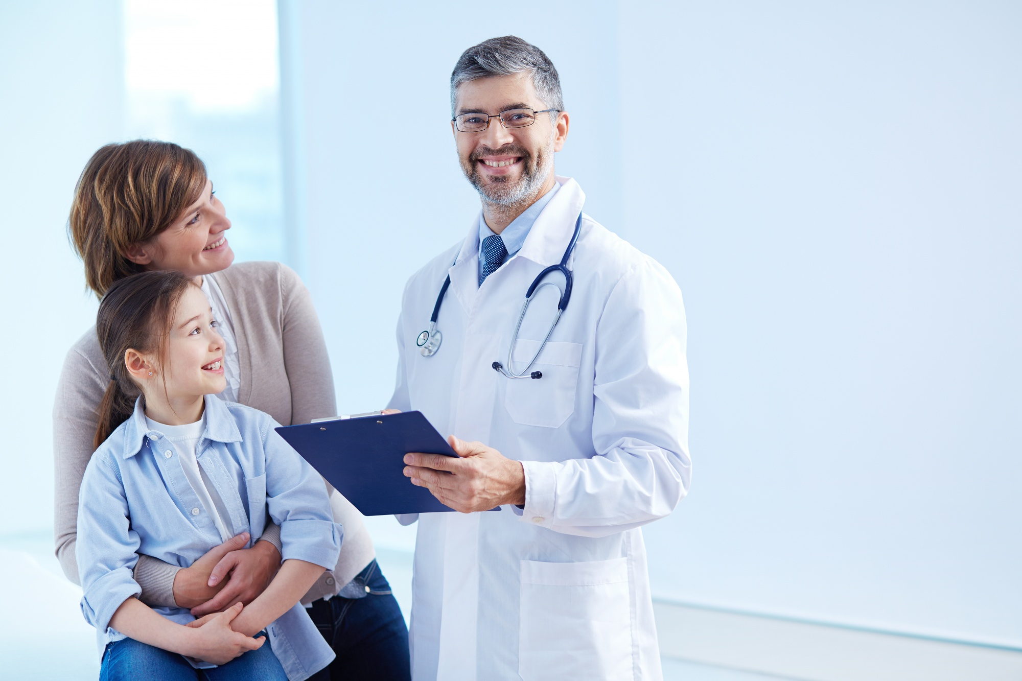 Doctor speaking with a parent and child at a clinic