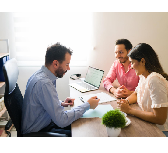 Advisor explaining a policy to a couple across a desk